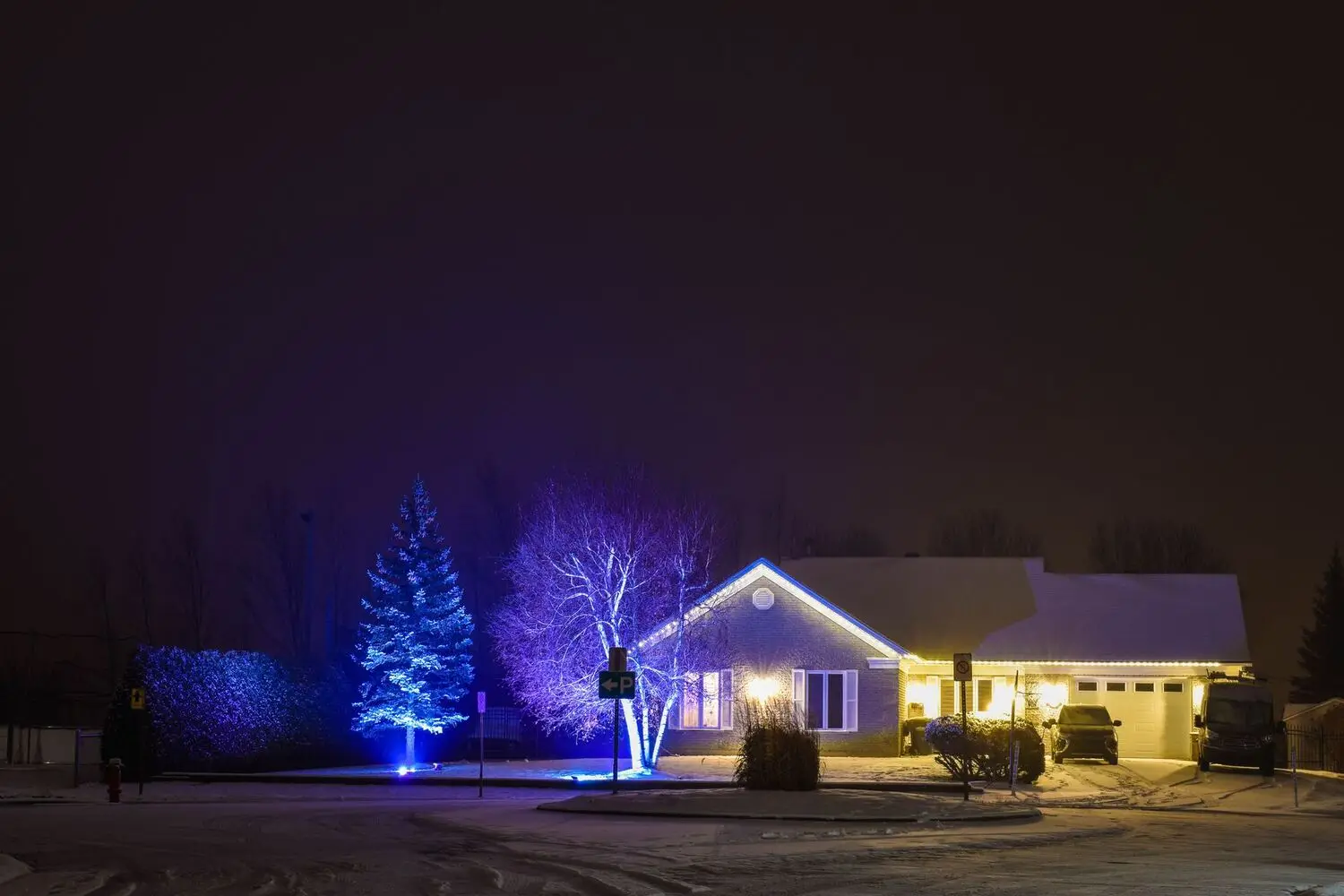 Suburban home lit on a snowy night