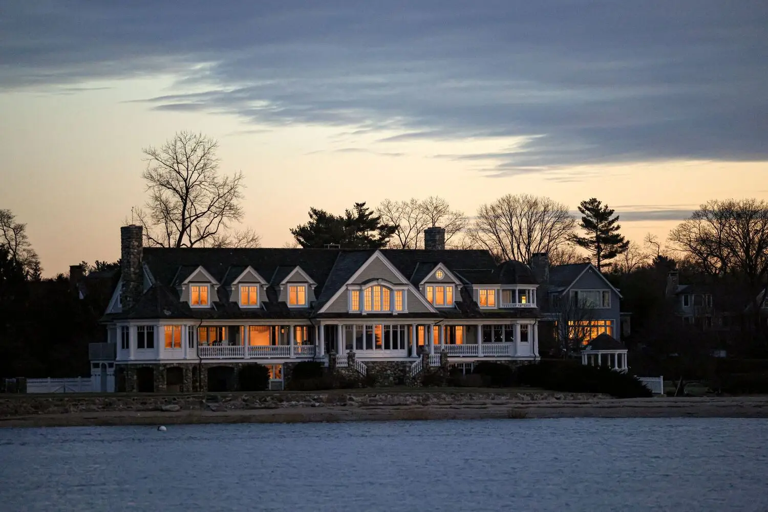 Large home at twilight with windows glowing