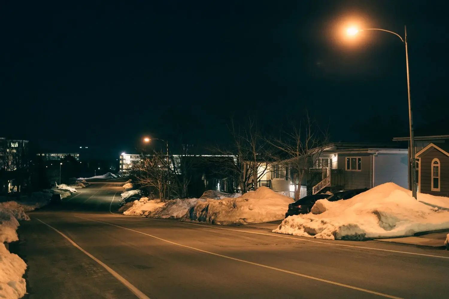 Urban street of houses lit at night in winter