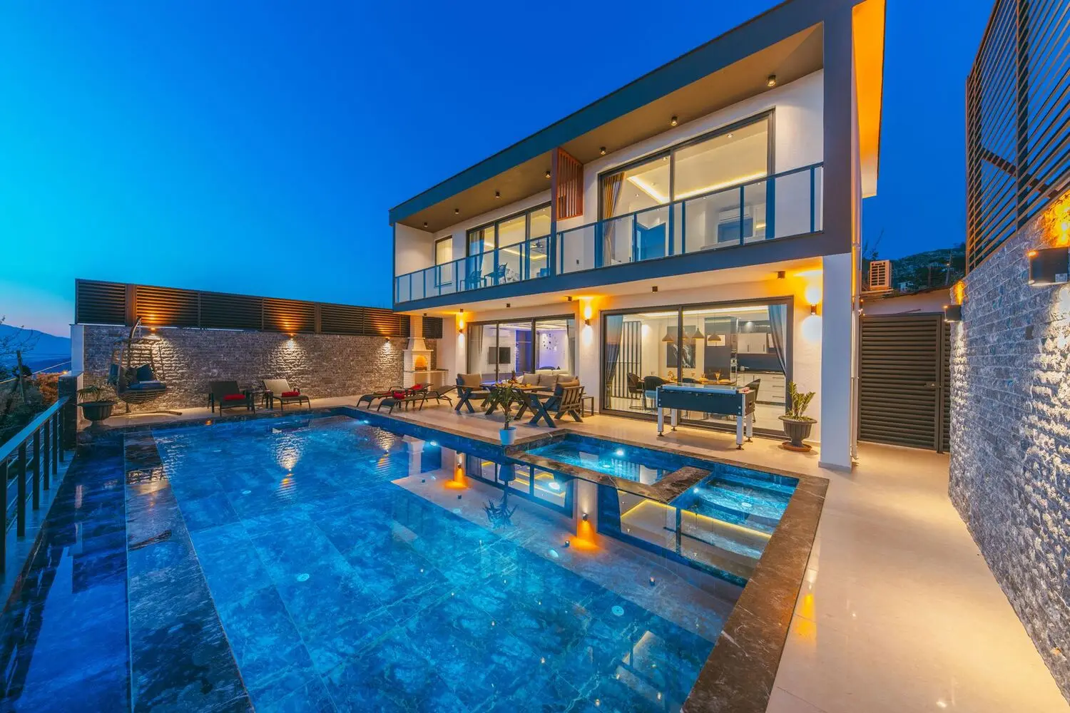 Modern house and pool terrace lit at dusk